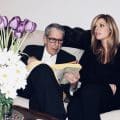 Leonard Cohen and Lonelle Selbo sit on Leonard's couch in his Montreal home while he looks up the number for the chicken place in the phone book.