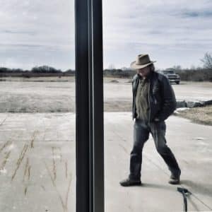 Dan Sullivan, Winemaker at Rosehall Run Vineyard walks past the glass doors of the winery.