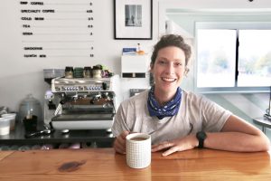 Chef Alexandra Feswick holds a cup of coffee behind the counter at Fawn Over Market in Prince Edward County.
